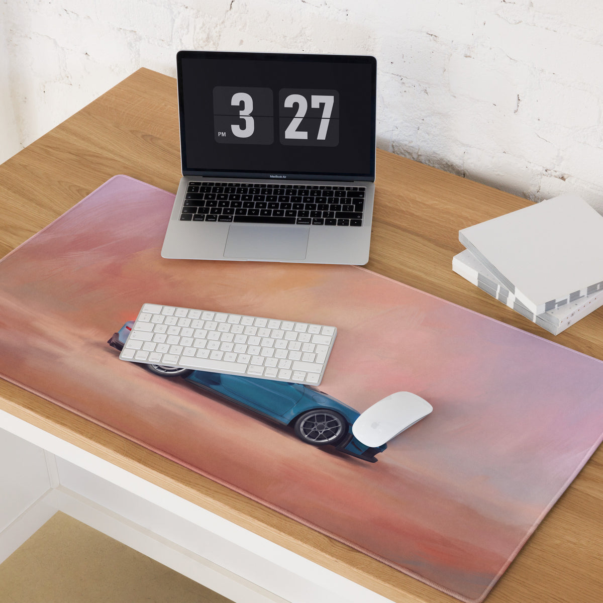 A sleek rectangular desk mat with vibrant pink and orange gradient and a blue porsche 911 gt3 sports car design