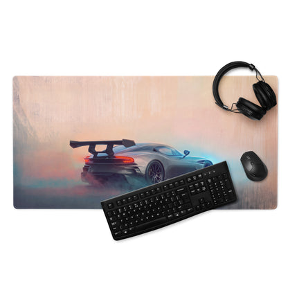 A sleek matte finish gunmetal gaming mousepad with stitched edges featuring a silver aston martin vulcan sports car graphic