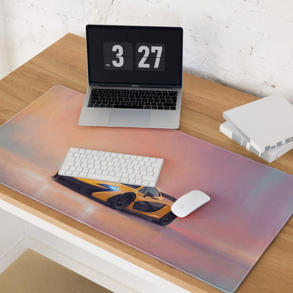 A sleek rectangular low-friction cloth desk mat featuring a vibrant orange mclaren p1 against a pink purple sky