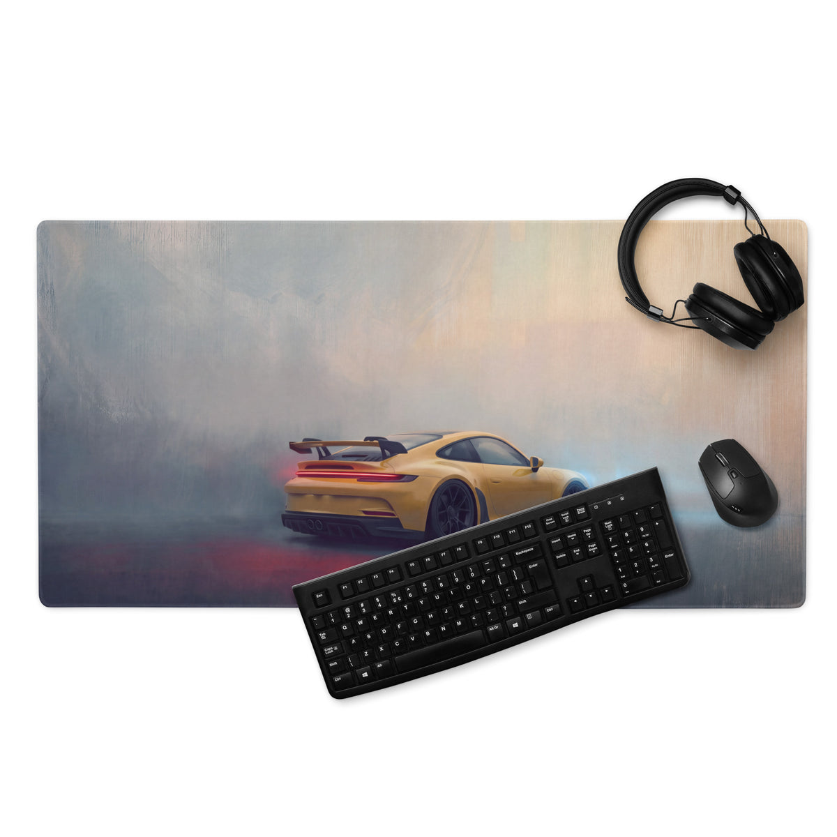 Yellow sports car graphic on black XL gaming mousepad featuring Porsche 911 GT3 inspired speed design with keyboard and headphones nearby