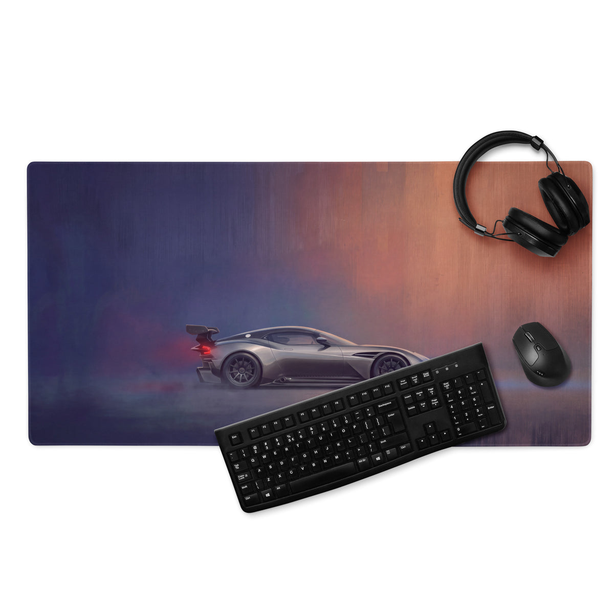 Aston Martin Vulcan inspired charcoal stealth desk pad with silver racing car graphic on blue and orange gradient background