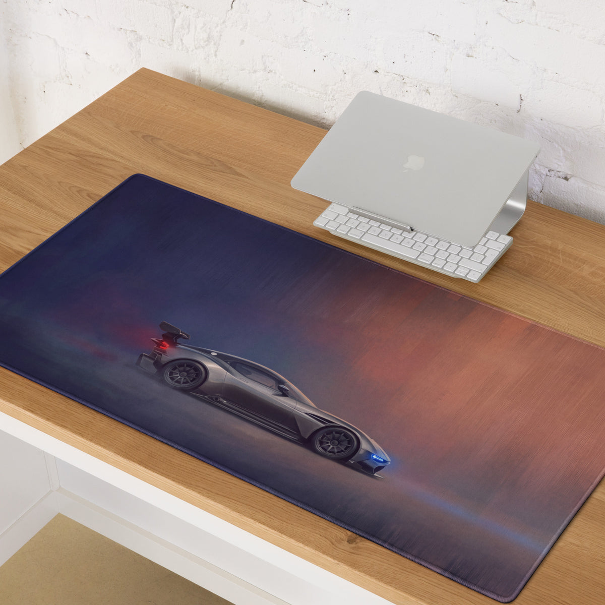 Aston Martin Vulcan inspired charcoal stealth desk pad with stitched edge featuring a sleek sports car and gradient background