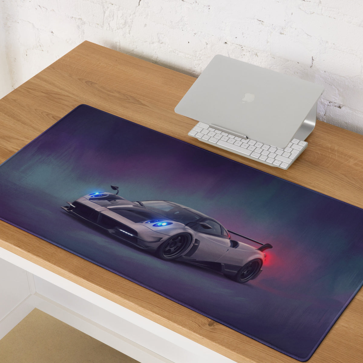 Pagani Huayra inspired silver carbon desk pad featuring a sleek gaming mousepad with blue headlights on purple teal background