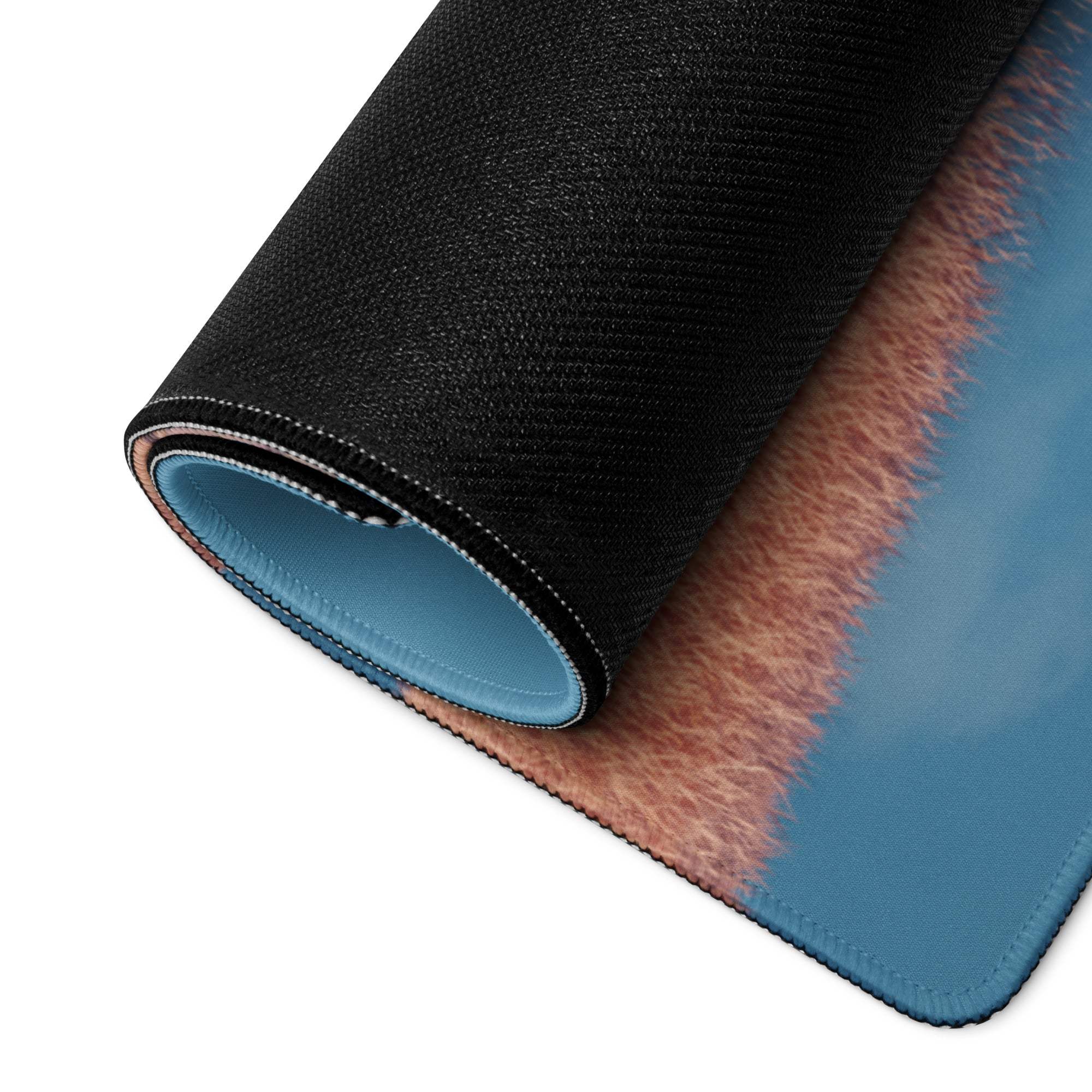 Black and blue textured gaming mousepad with fuzzy pinkish-brown border