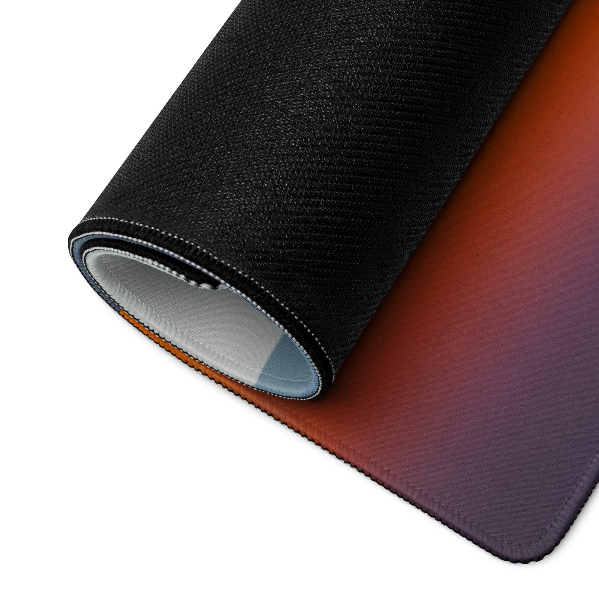Black textured gaming mousepad with orange-to-purple sunset gradient and stitched edges