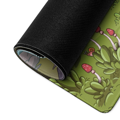 Rolled-up green gaming mouse pad with red mushrooms, snails, plants