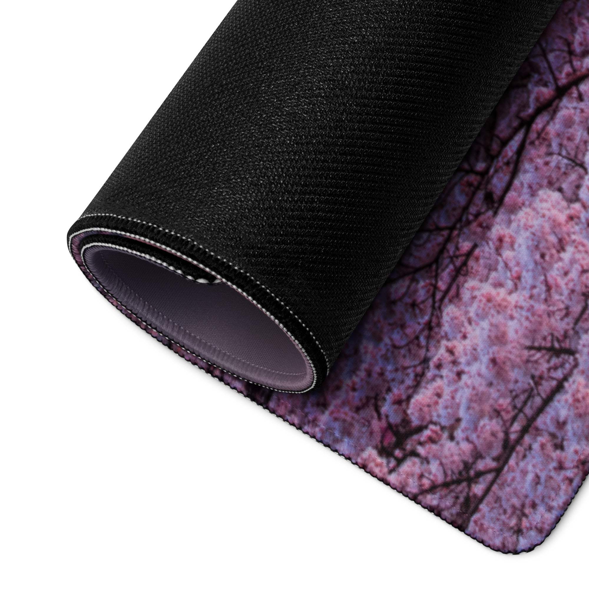 Rolled-up black gaming mousepad with pink purple sakura design