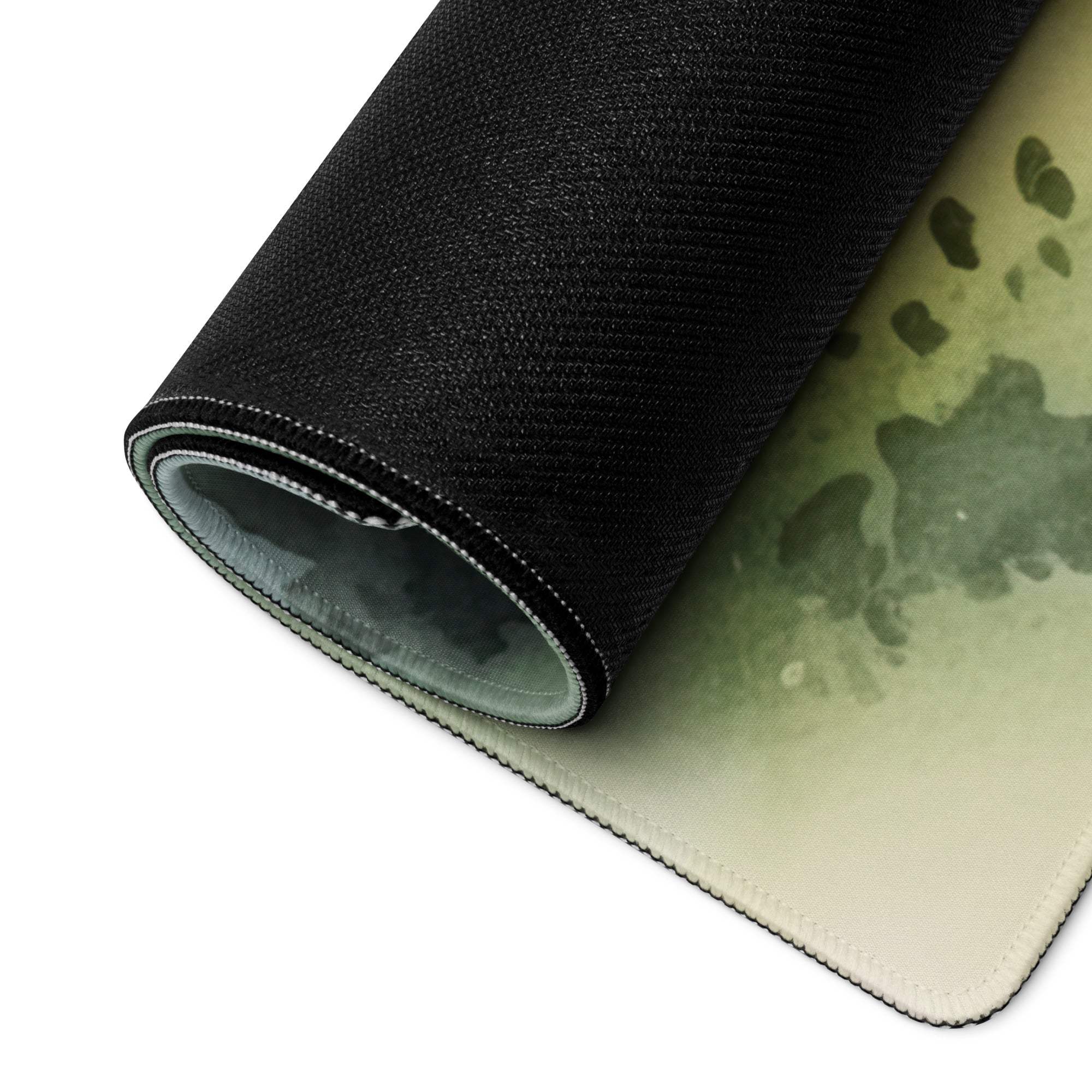 Rolled watercolor forest camo gaming mouse pad in green tones, non-slip back