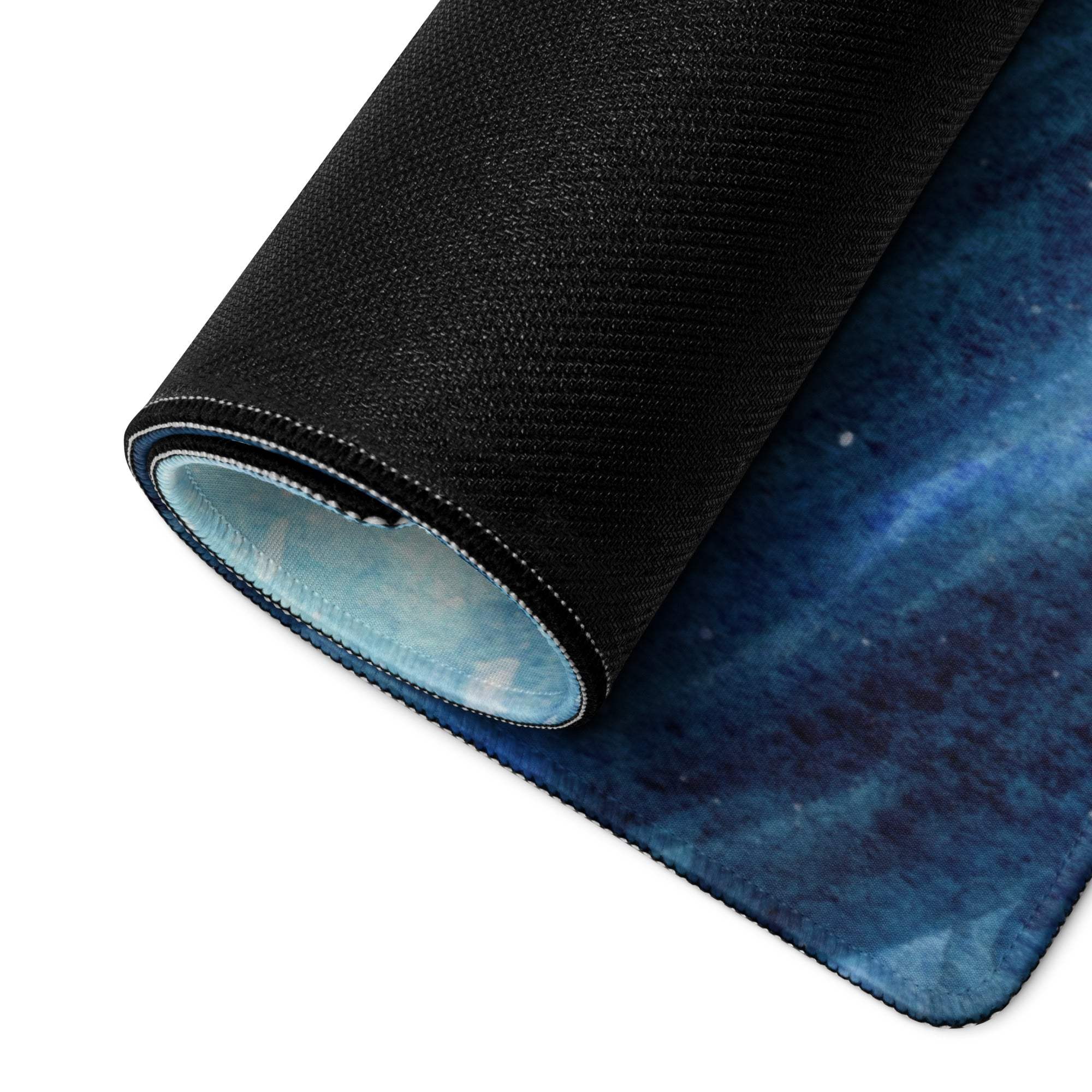 Rolled blue galaxy mousepad with ocean wave design, stitched edges, non-slip back