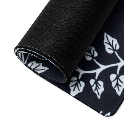 Large black gaming mouse pad with white leafy branches, stitched edges