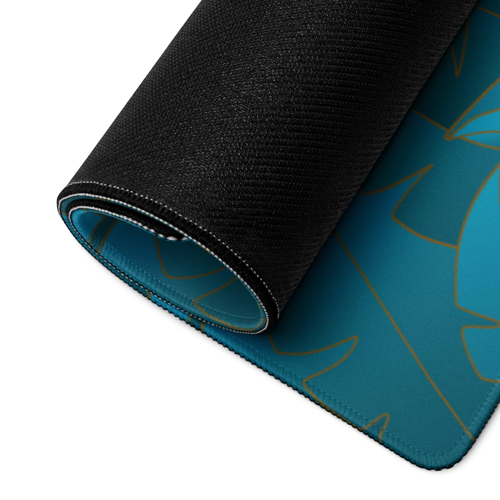 Teal gaming mousepad with gold leaf pattern, black textured edges, non-slip base