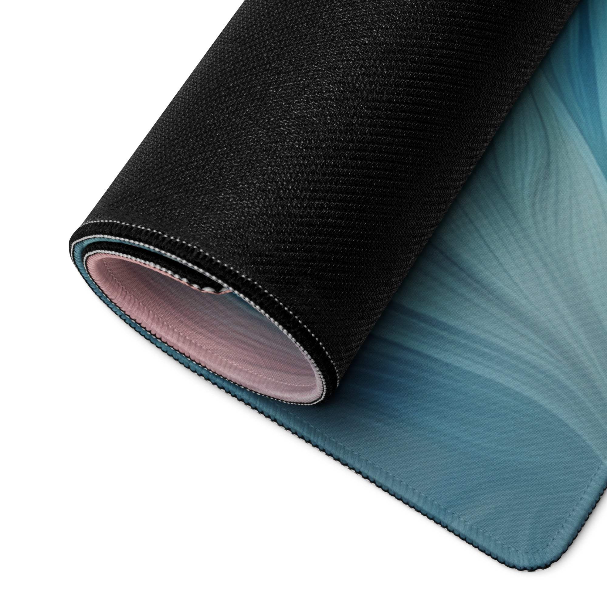 Rolled-up black teal gradient gaming mouse pad with pink lining stitched edges