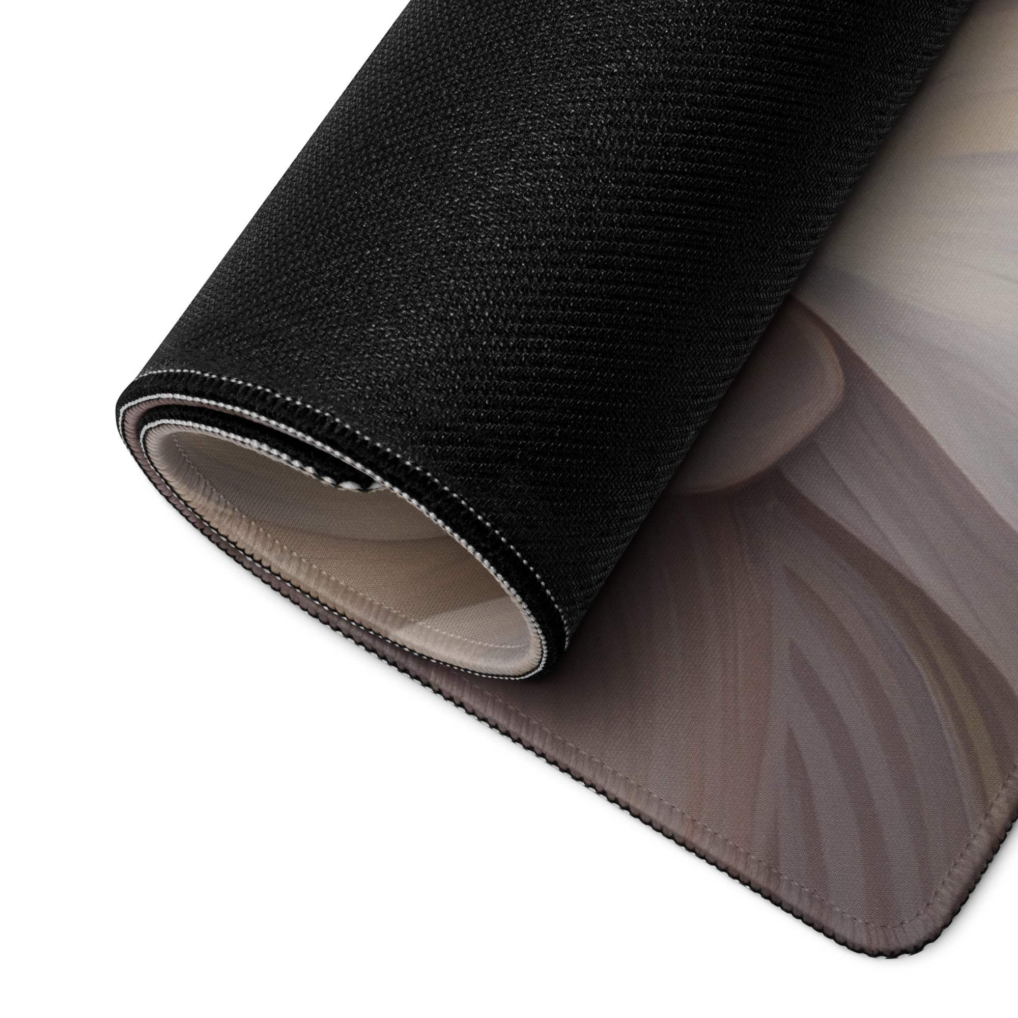 Black textured fabric roll with gray white design on edge of beige floral gaming mouse pad