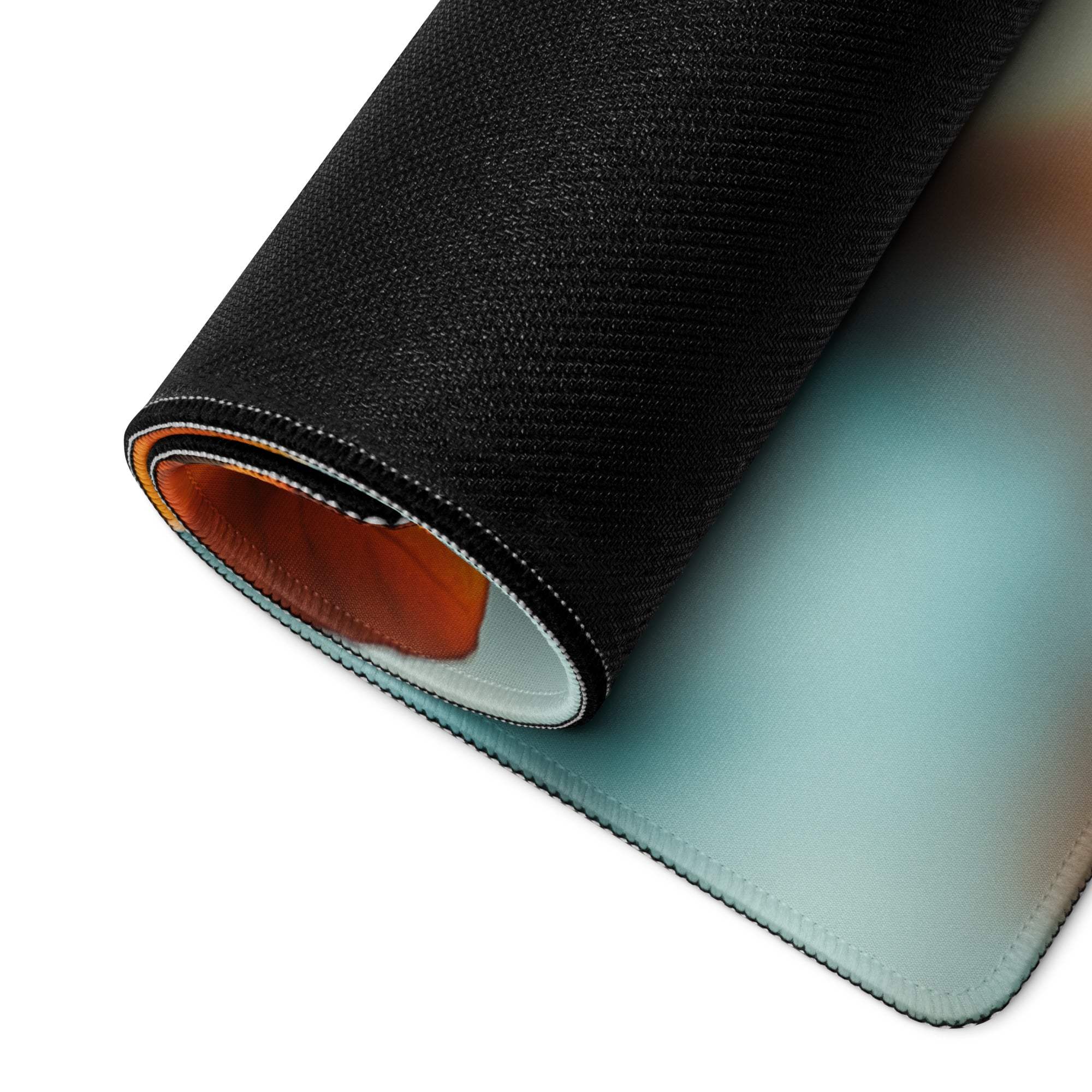Black textured Autumn Leaves gaming mousepad rolled to show blue-orange gradient layers