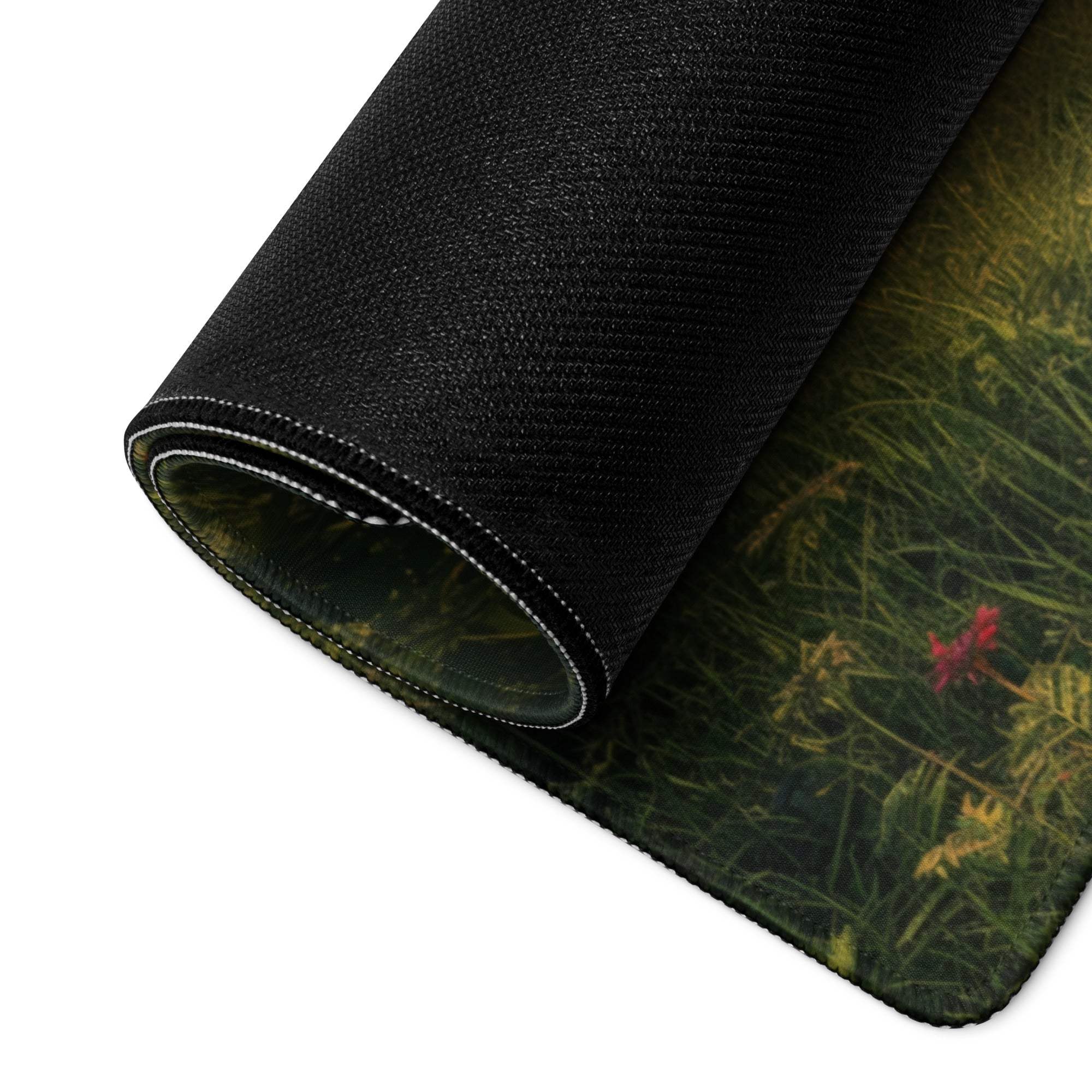 Black textured gaming mousepad with green grass, red flowers, stitched edges