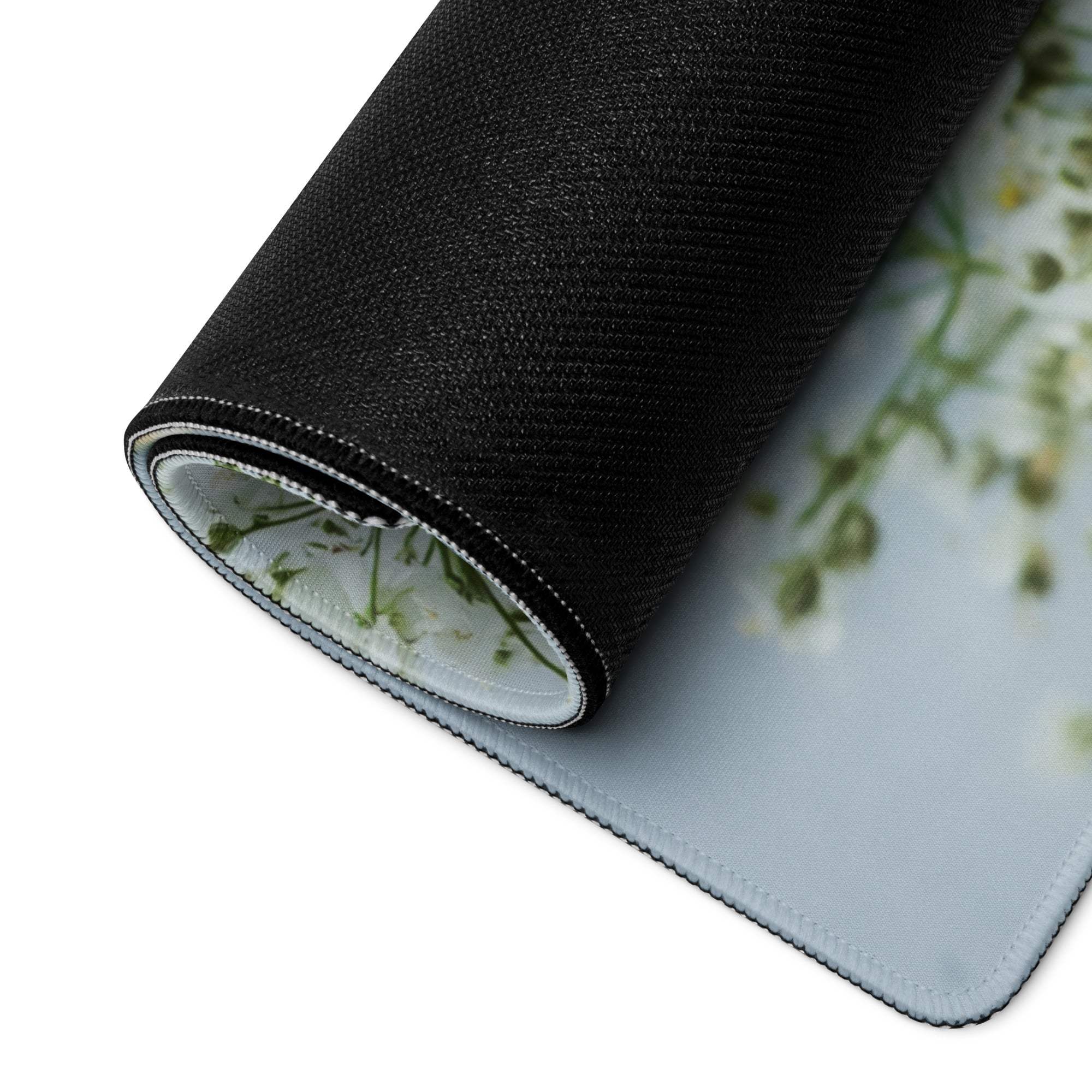 Black rolled-up gaming mouse pad with white green floral design