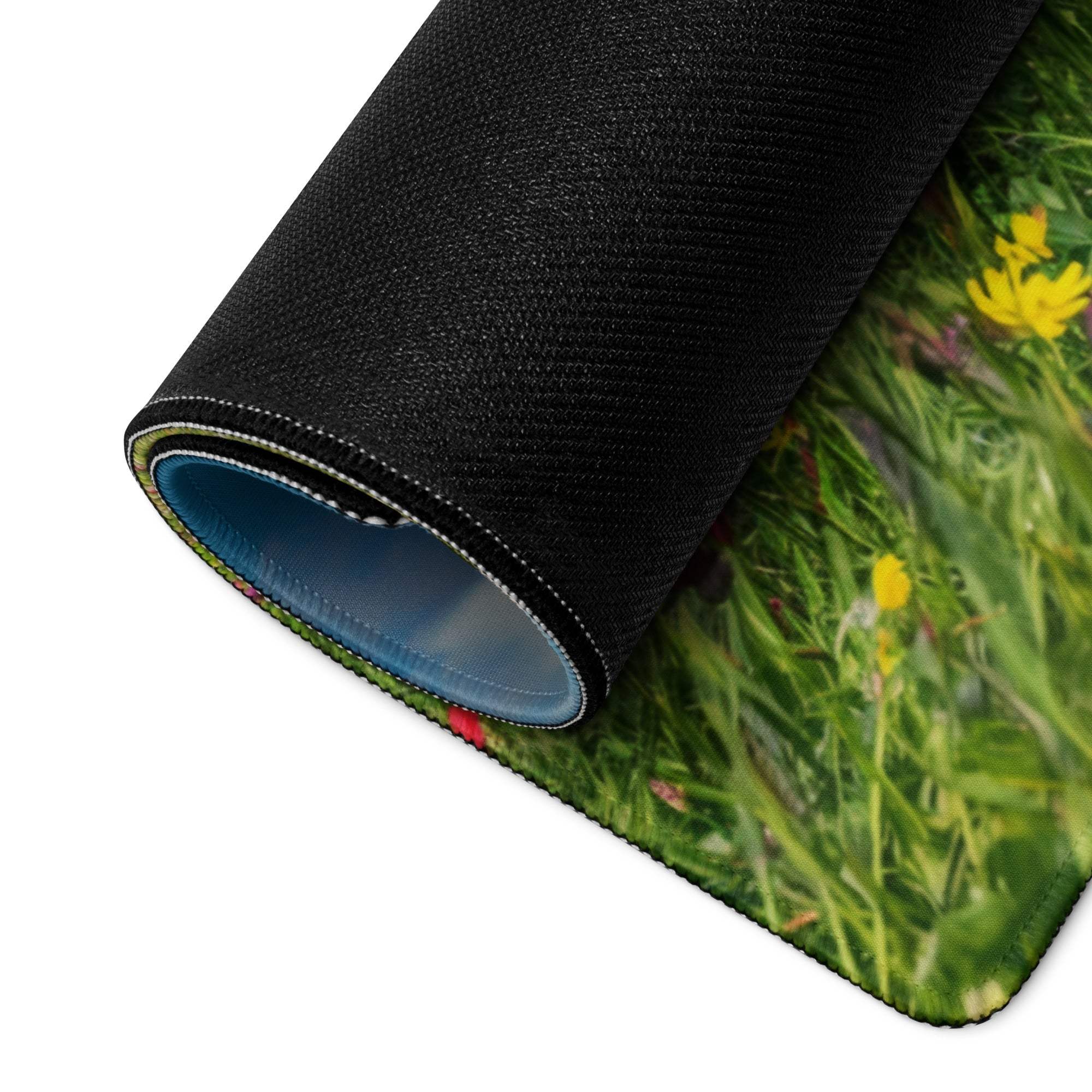 Black rolled-up Epic Majestic gaming mousepad with green meadow and flowers