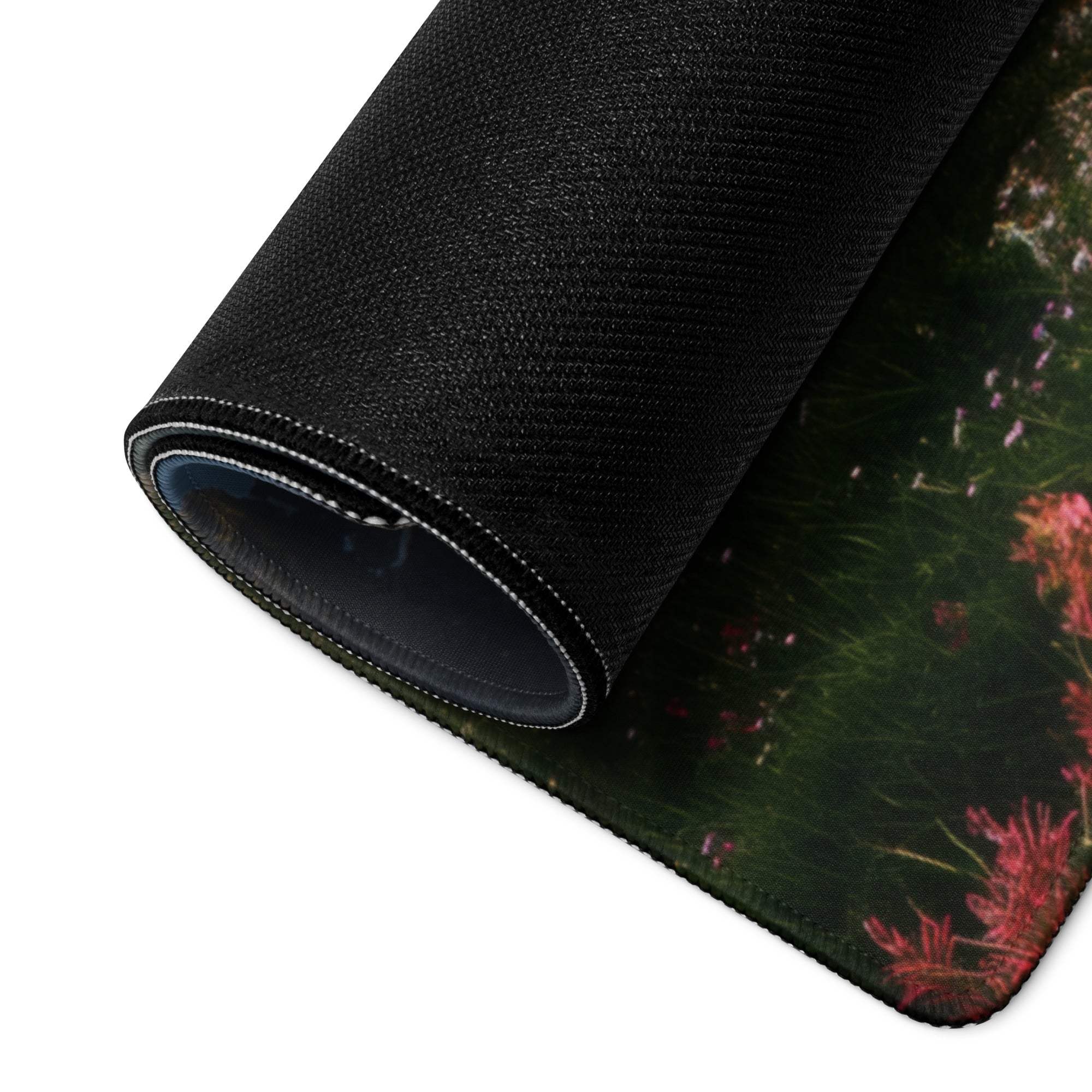 Black textured gaming mousepad with rolled edge, pink flowers, green grass meadow