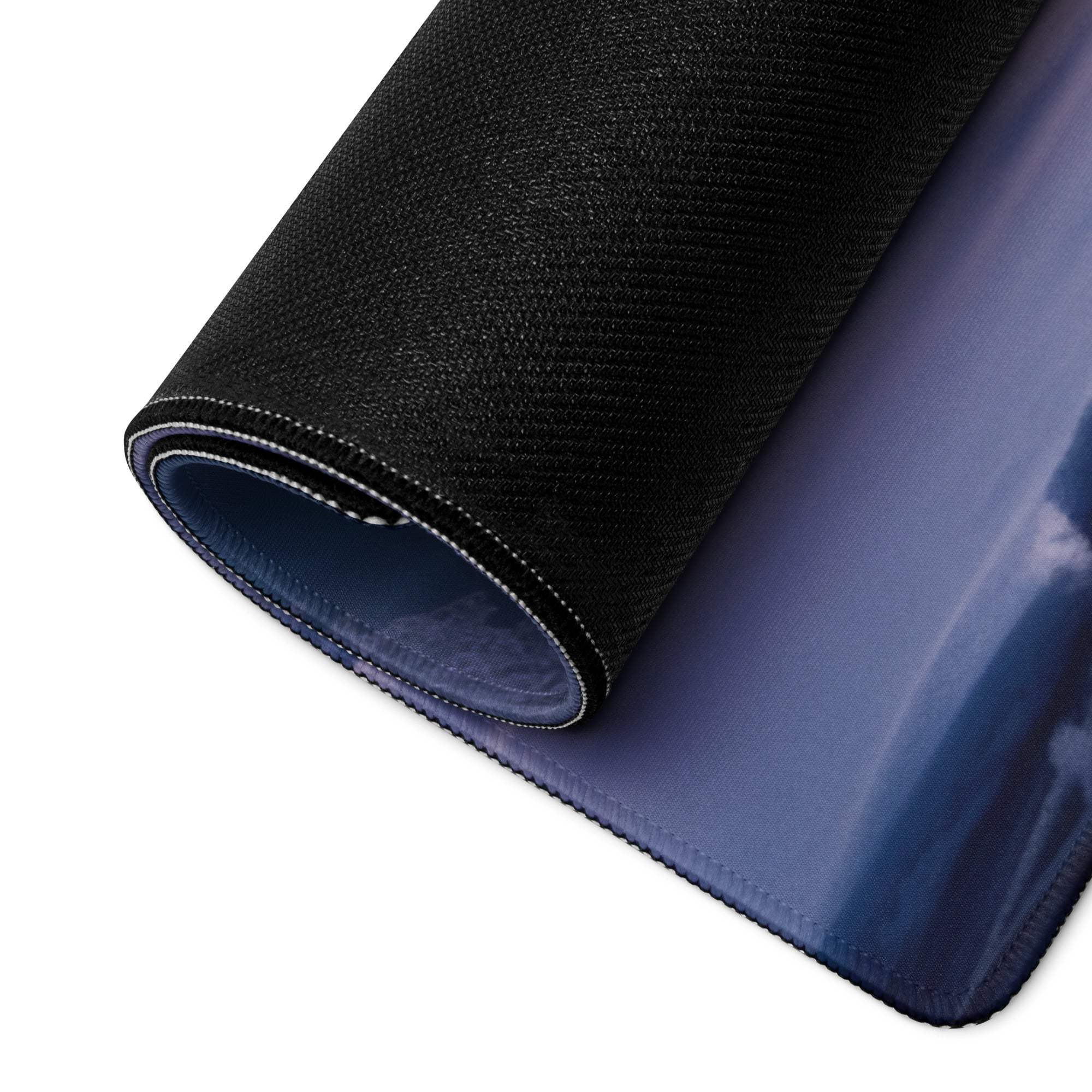 Back of Tranquil Winter Forest gaming mouse pad with black textured outer layer and glossy navy blue inner surface