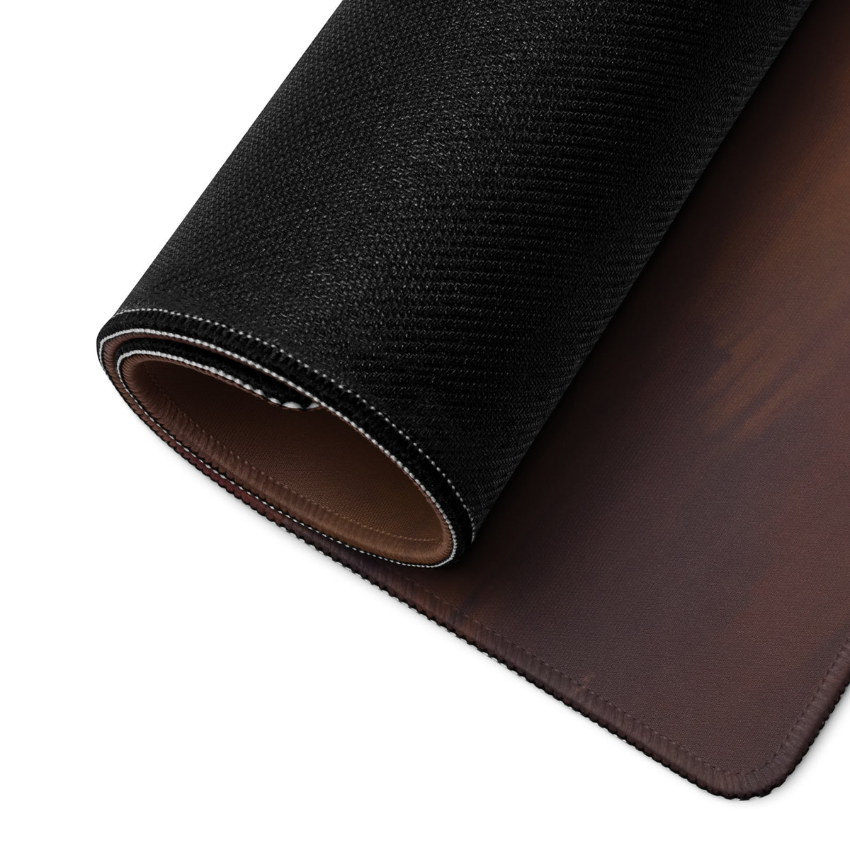Audi R8 inspired midnight stealth desk mat with black textured outer layer and brown leather interior rolled for display