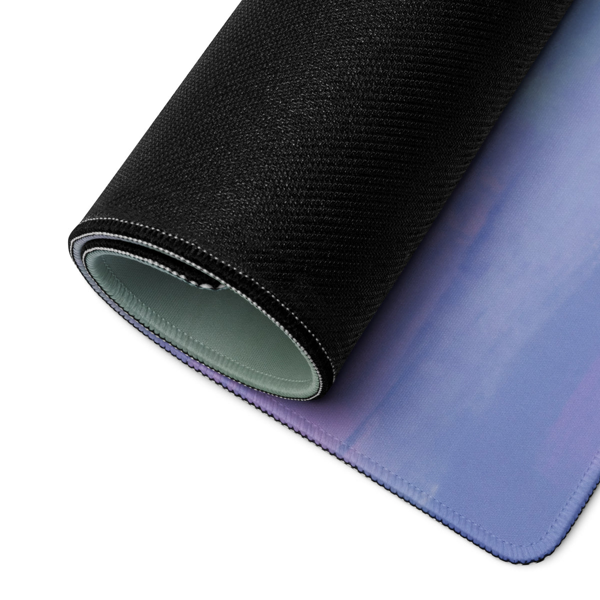 Rolled-up black and purple gradient ferrari 488 gt3 inspired modena circuit desk pad with stitched edges and textured surface