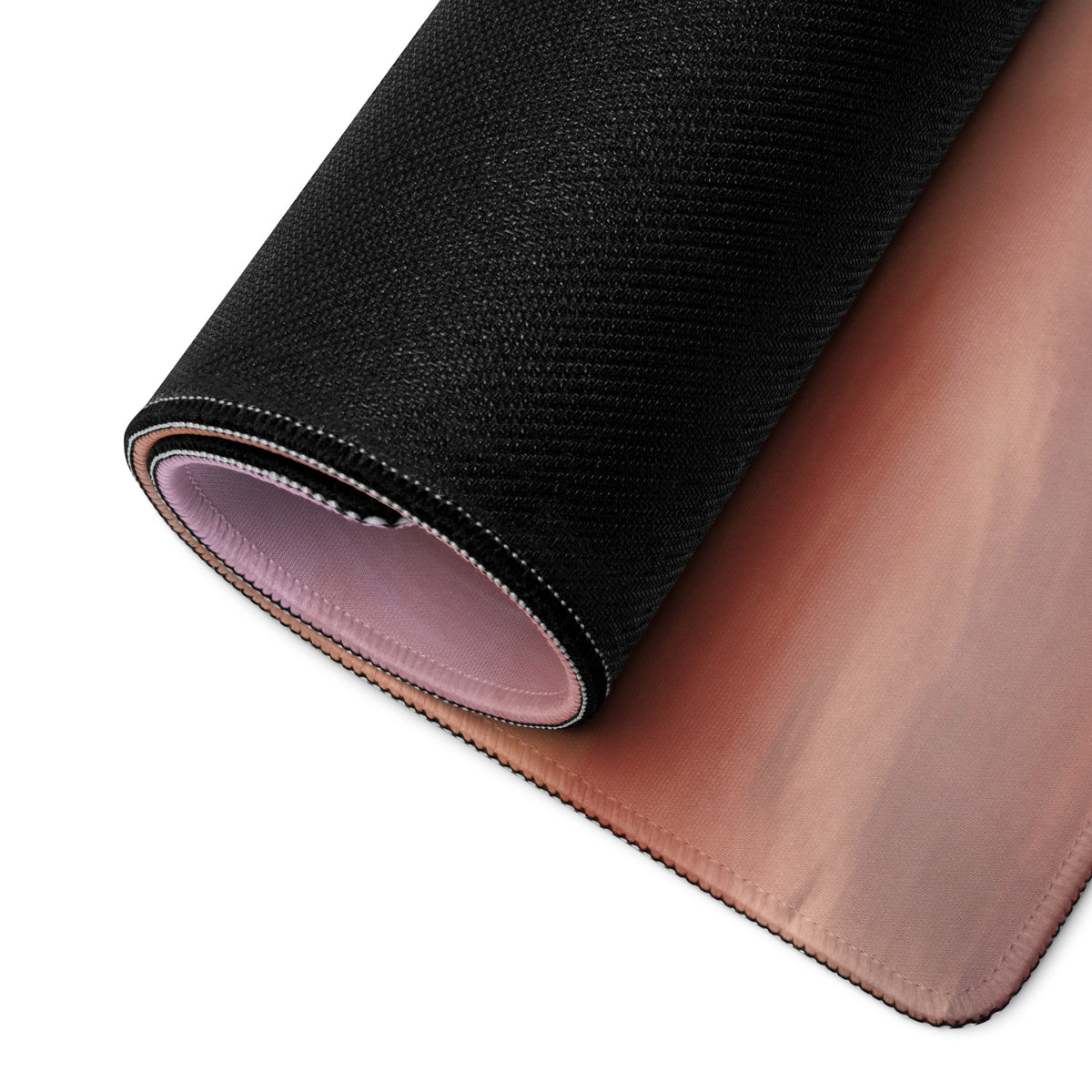 Porsche 911 gt3 inspired riviera sunset desk mat with black textured outer layer and soft pink inner lining rolled to show design