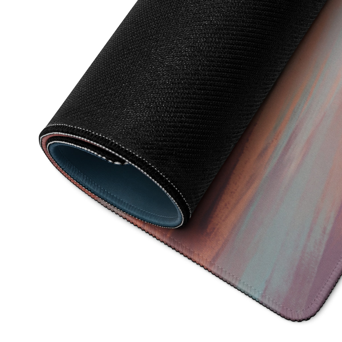 A rolled-up black porsche 911 gt3 rs inspired irish green desk pad with a gradient pink mauve and teal non-slip surface