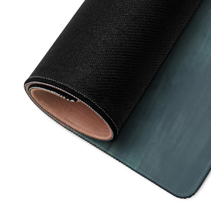 Black textured outer layer with teal stitched edges rolled to show layered construction of mclaren 765lt stealth onyx desk mat