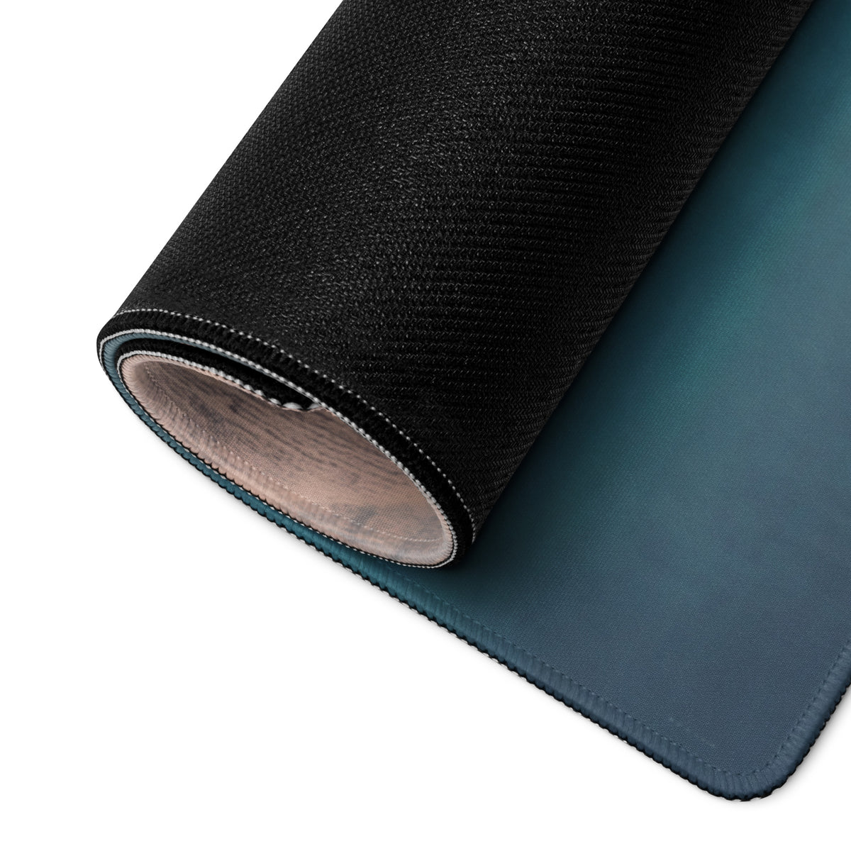 Rolled-up mclaren p1 inspired silver orange track edition desk mat with dark teal cloth top and textured black stitched back