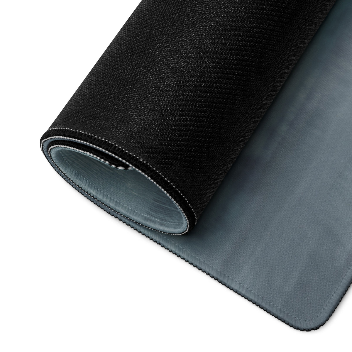 Black textured Lamborghini Aventador inspired arancio widebody desk pad with gray underside rolled to show layered construction