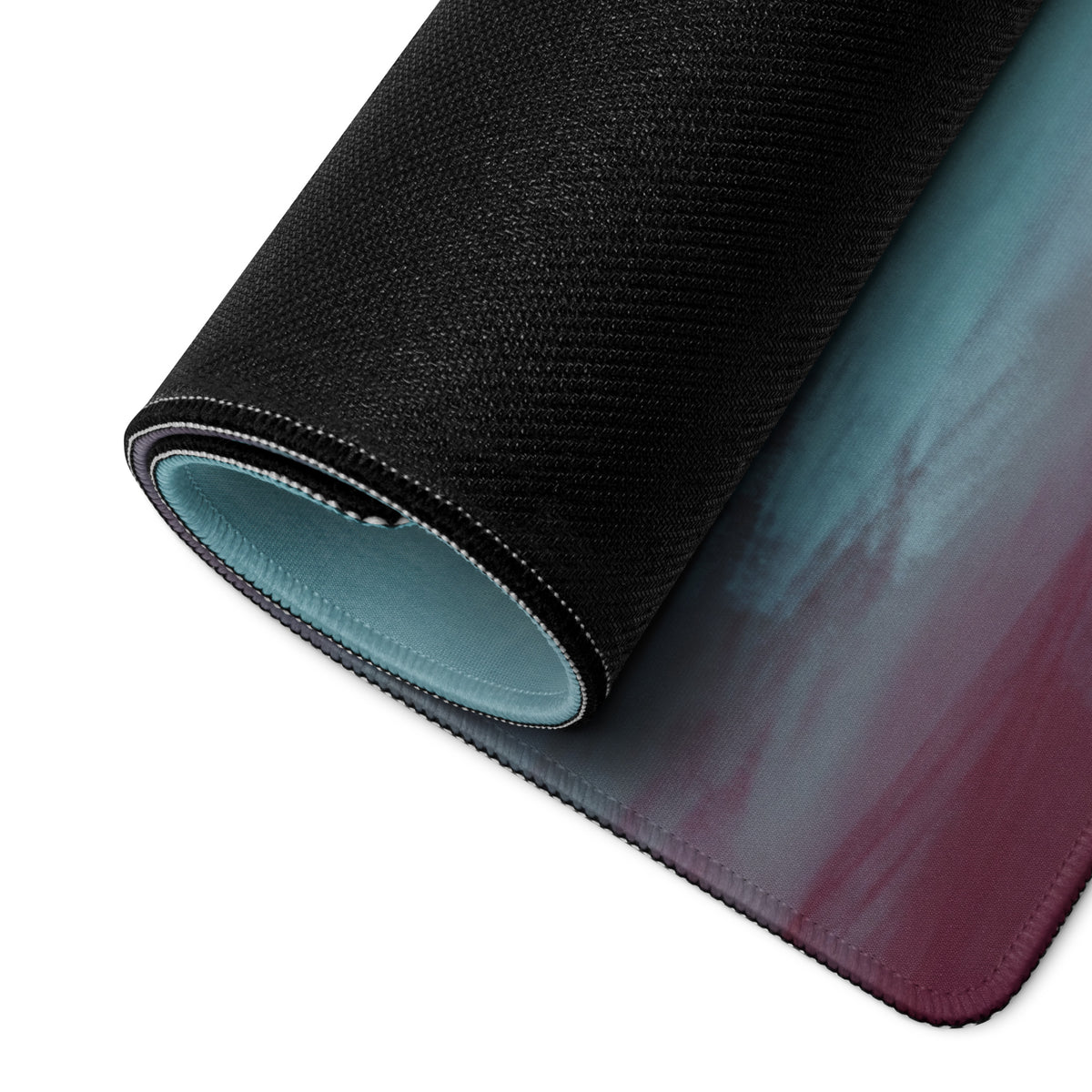 A rolled-up lamborghini centenario inspired carbon gold desk mat gaming mousepad with teal to burgundy gradient and textured black back