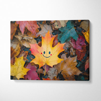 Canvas wall art featuring a vibrant autumn leaf with a smiling face among colorful fallen leaves.