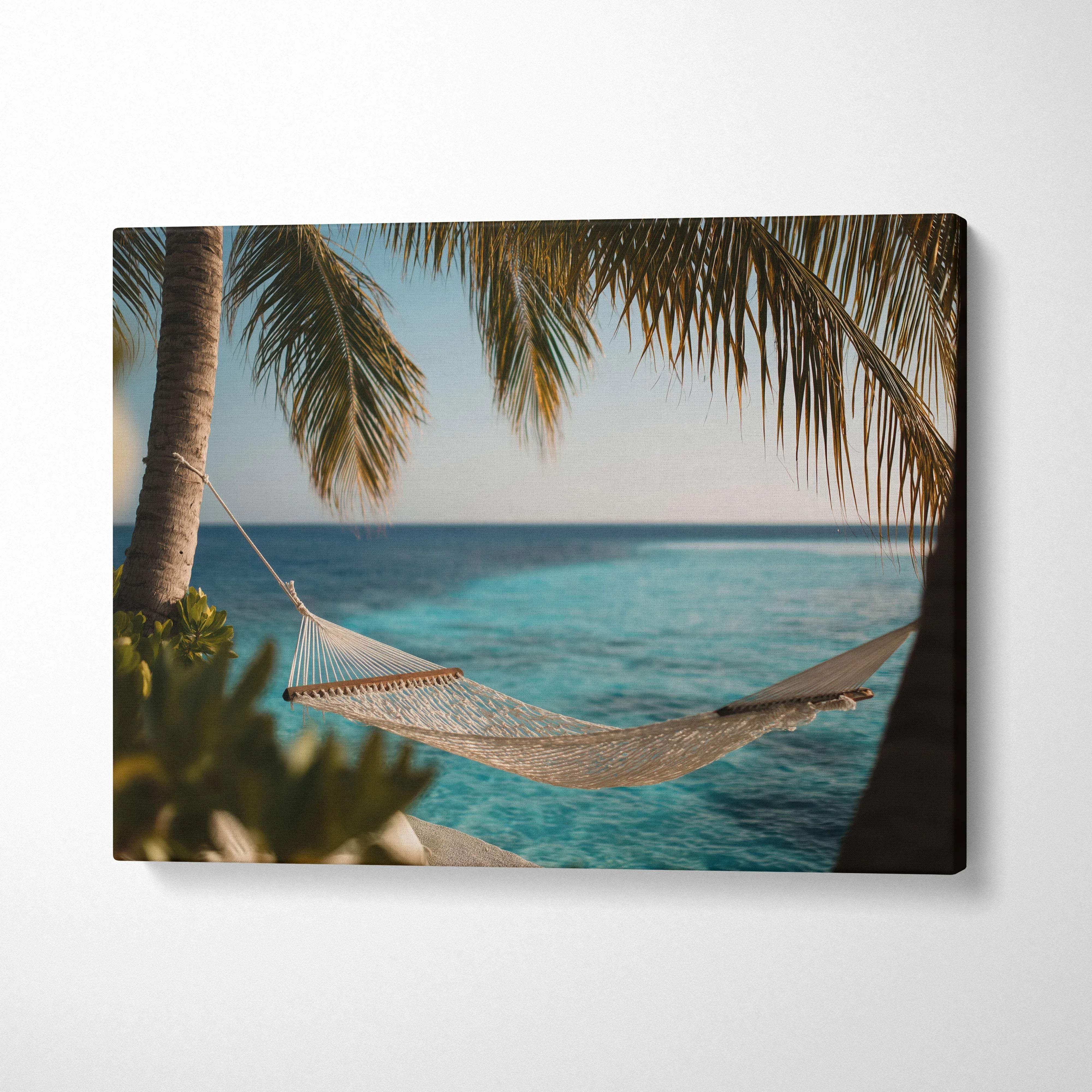 Serene beach scene canvas wall art with a hammock between palm trees over turquoise water.