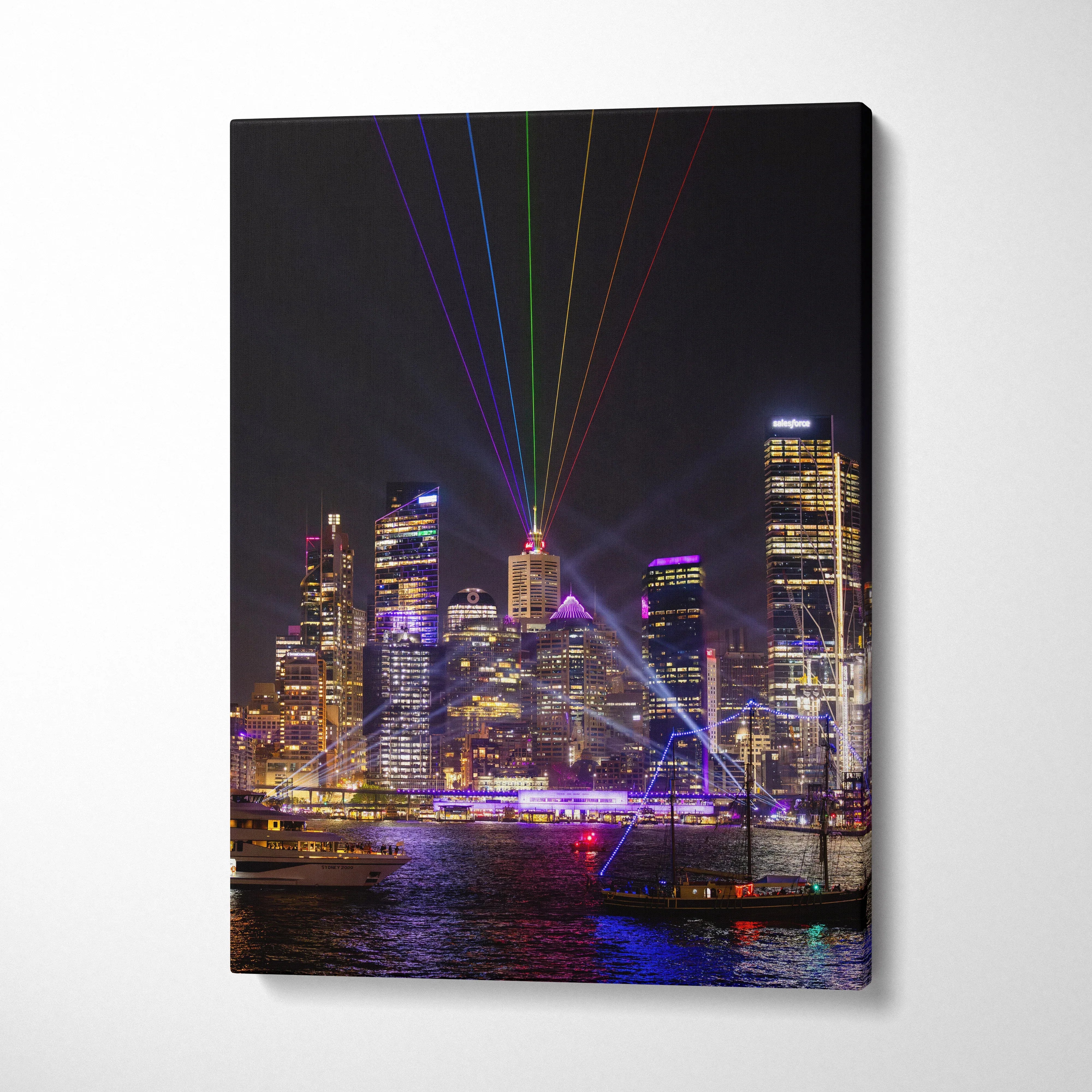 Urban skyline at night with colorful laser lights, printed on vertical canvas wall art.