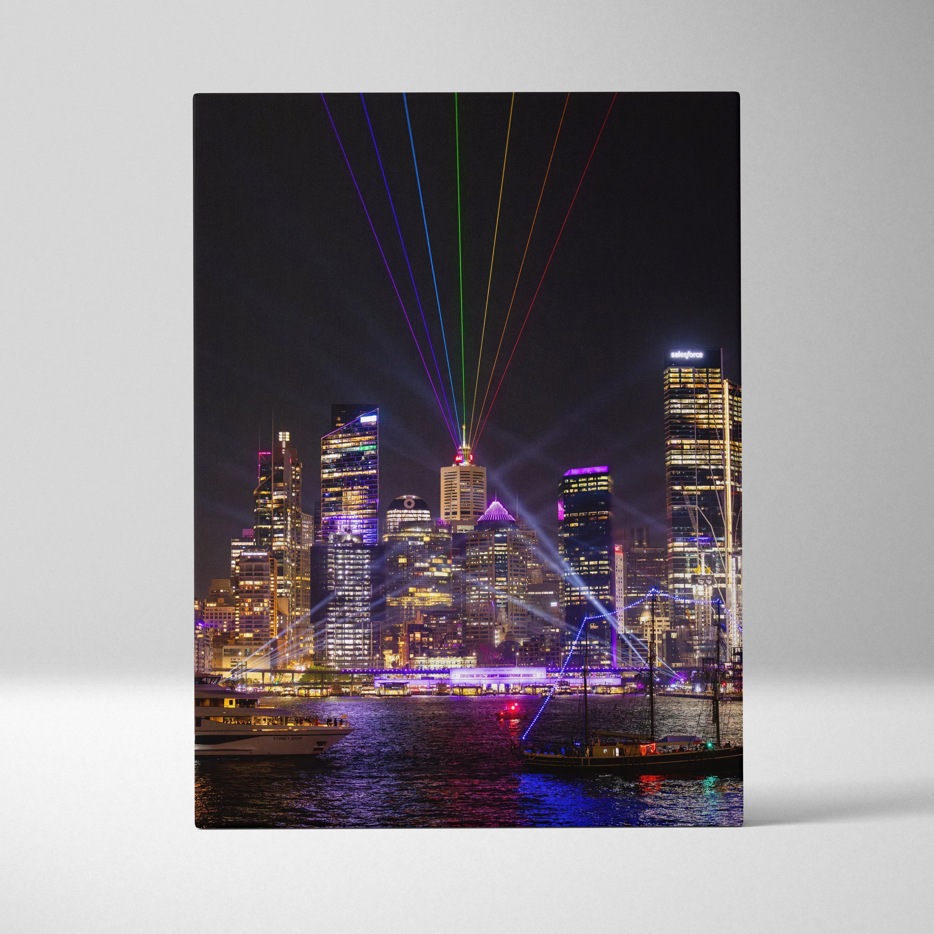 Vertical canvas wall art of vibrant urban skyline at night with colorful laser lights.