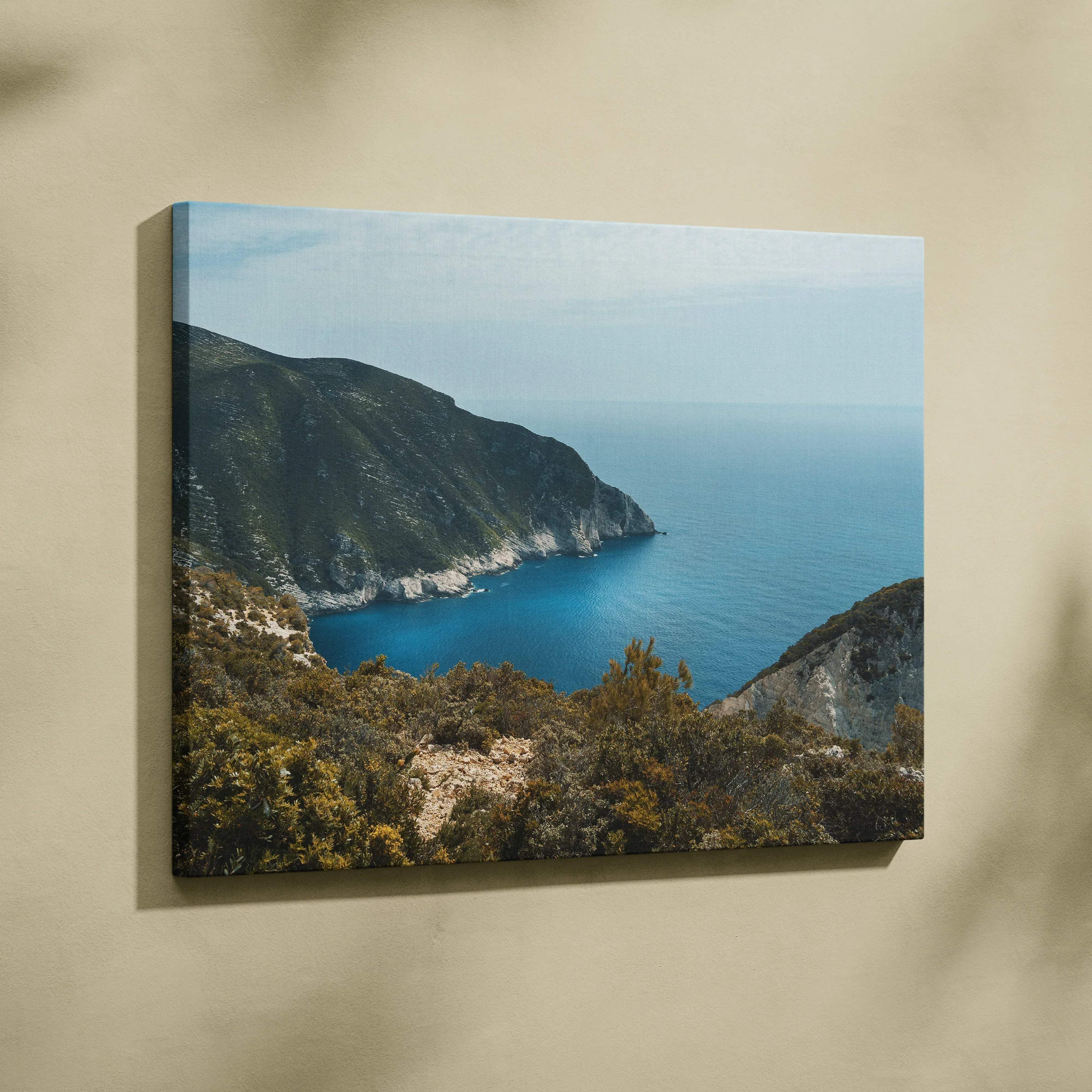 Beige wall-mounted canvas print of serene mountain and ocean landscape with blue seascape and green hills for living room decor