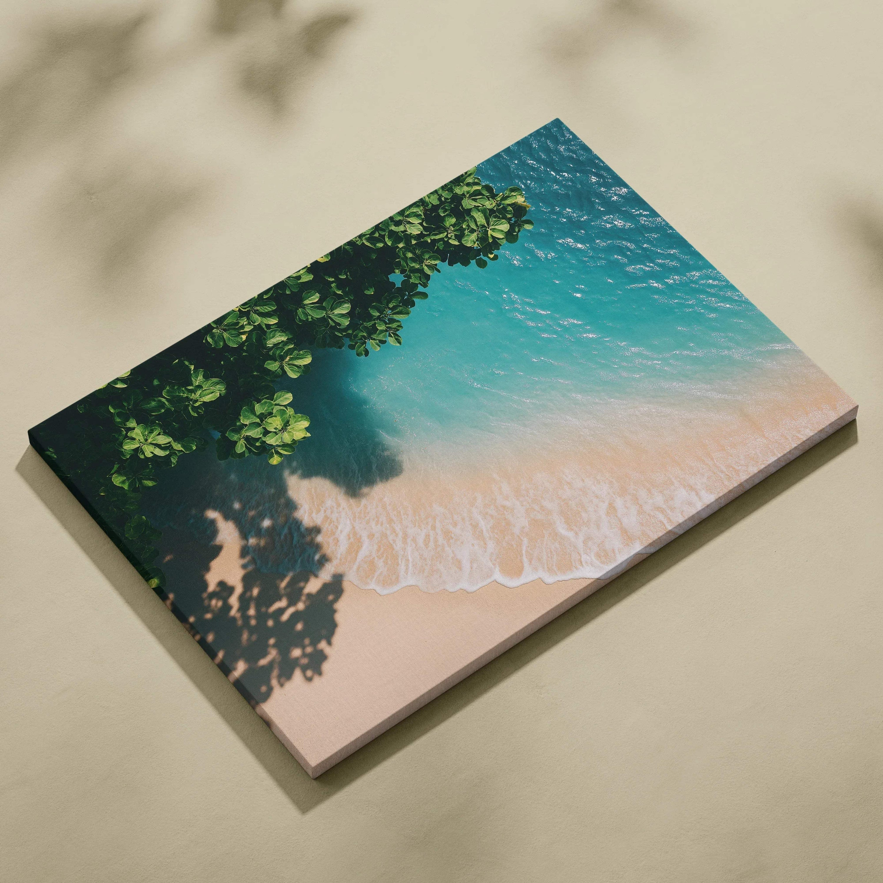 Tranquil beach scene canvas wall art with ocean waves and leafy shadows on sand.