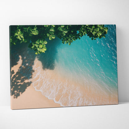 Canvas wall art of tranquil ocean waves gently washing onto sandy beach under leafy green tree shadows.