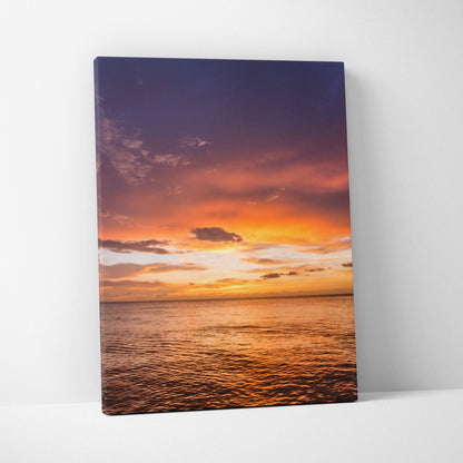 Canvas wall art featuring a vibrant ocean sunset with orange and purple skies over calm water.