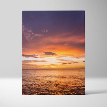 Ocean sunset with vibrant orange and purple sky over calm water on vertical canvas wall art.