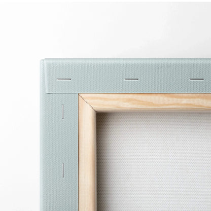 Close-up of light blue canvas stretched over wooden frame with staples, showing texture and craftsmanship of wall art canvas.