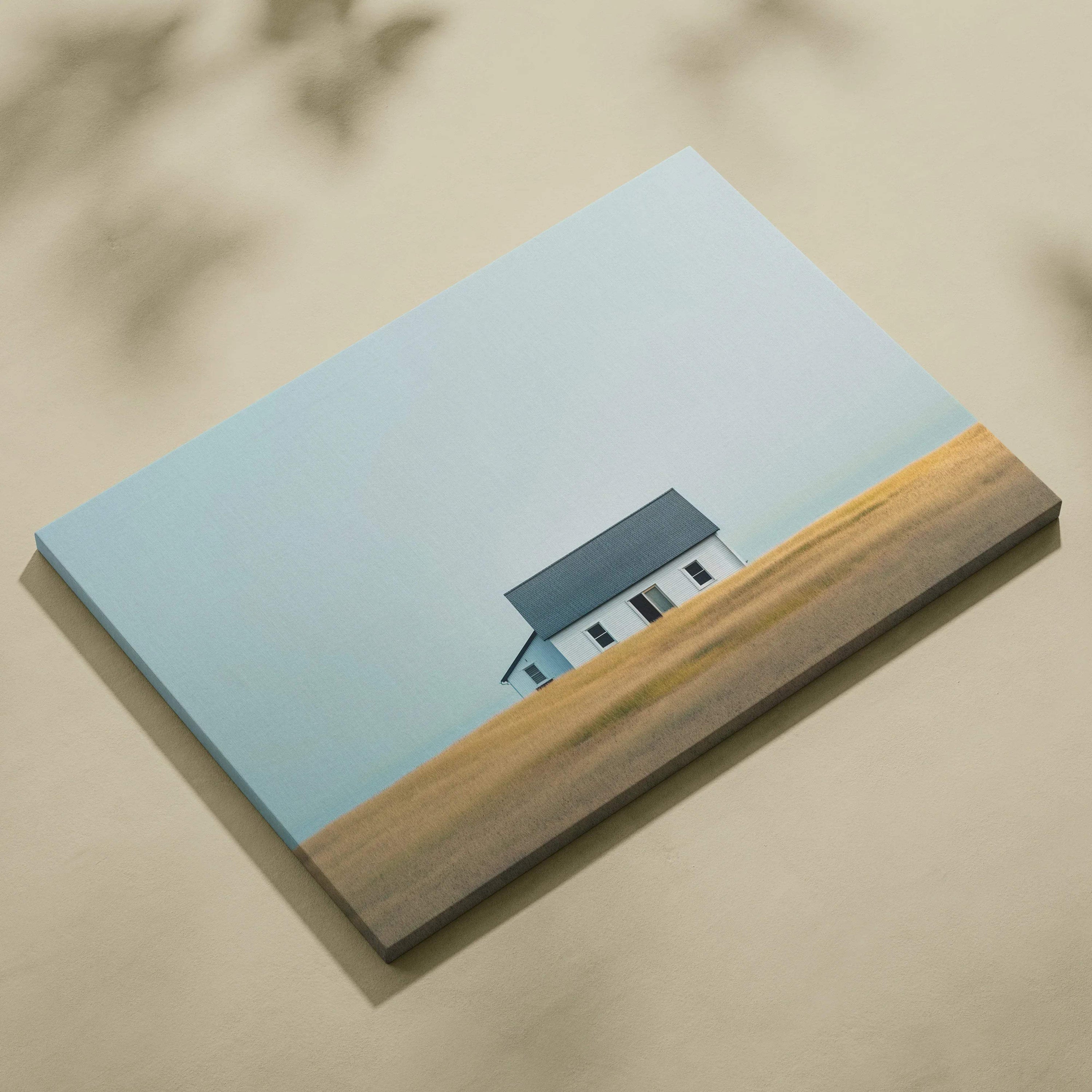 Minimalist canvas wall art featuring a small house against a clear blue sky and golden field.