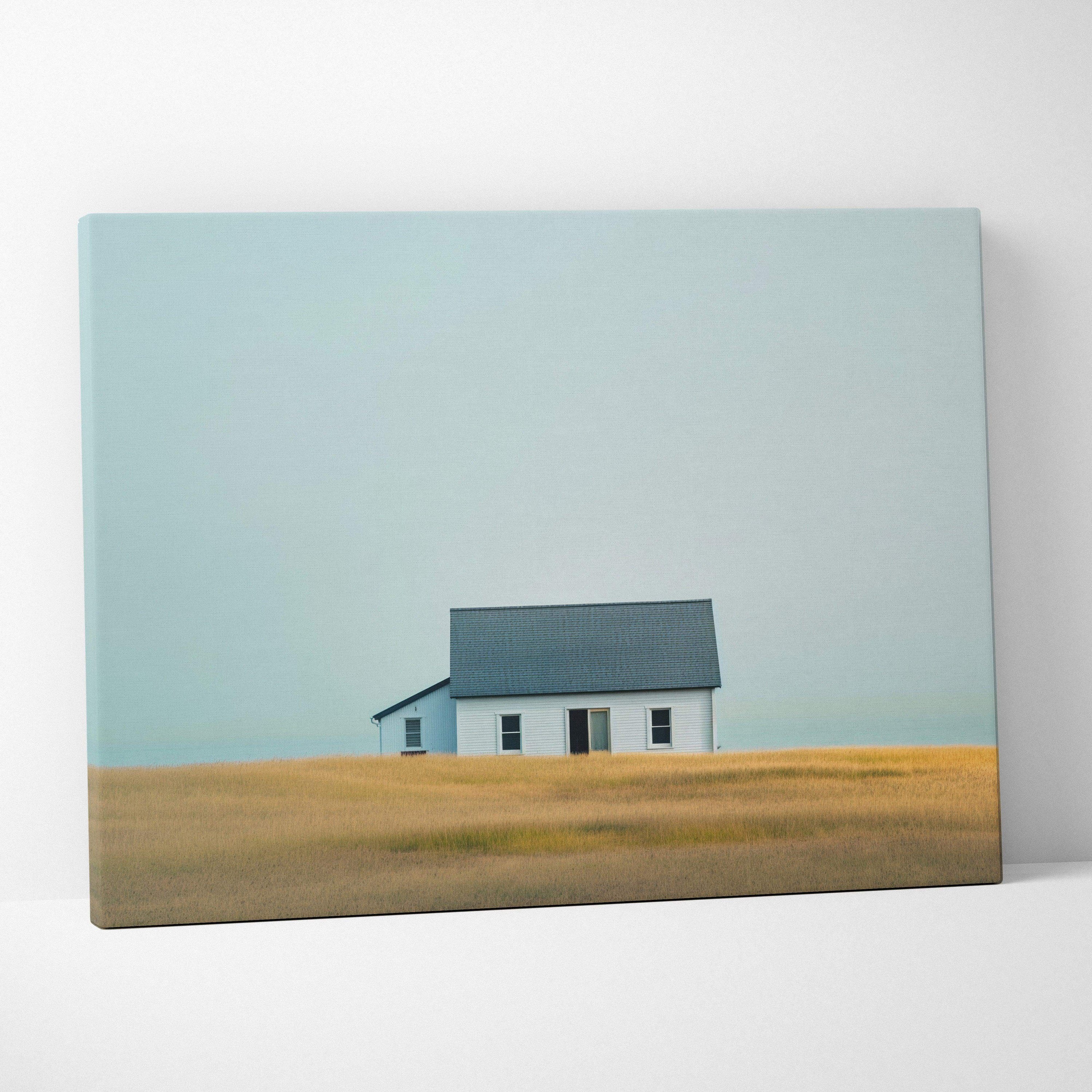 Canvas wall art featuring a minimalist house in a golden field under a pale blue sky.
