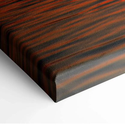 Close-up of vivid orange and black striped ocean sunset canvas wall art corner with textured surface.