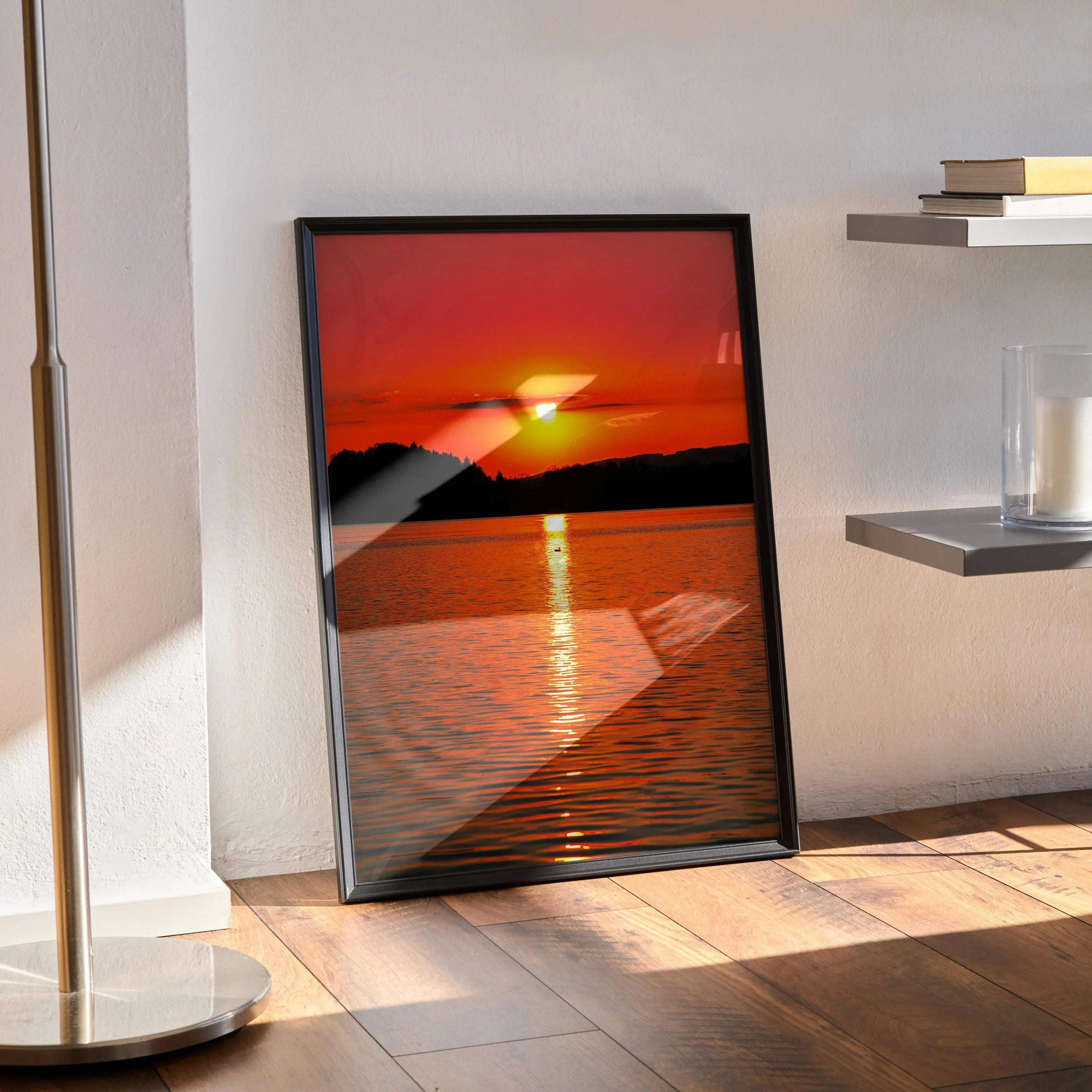 Serene ocean sunset poster with vibrant orange and red hues, framed wall art on wooden floor.