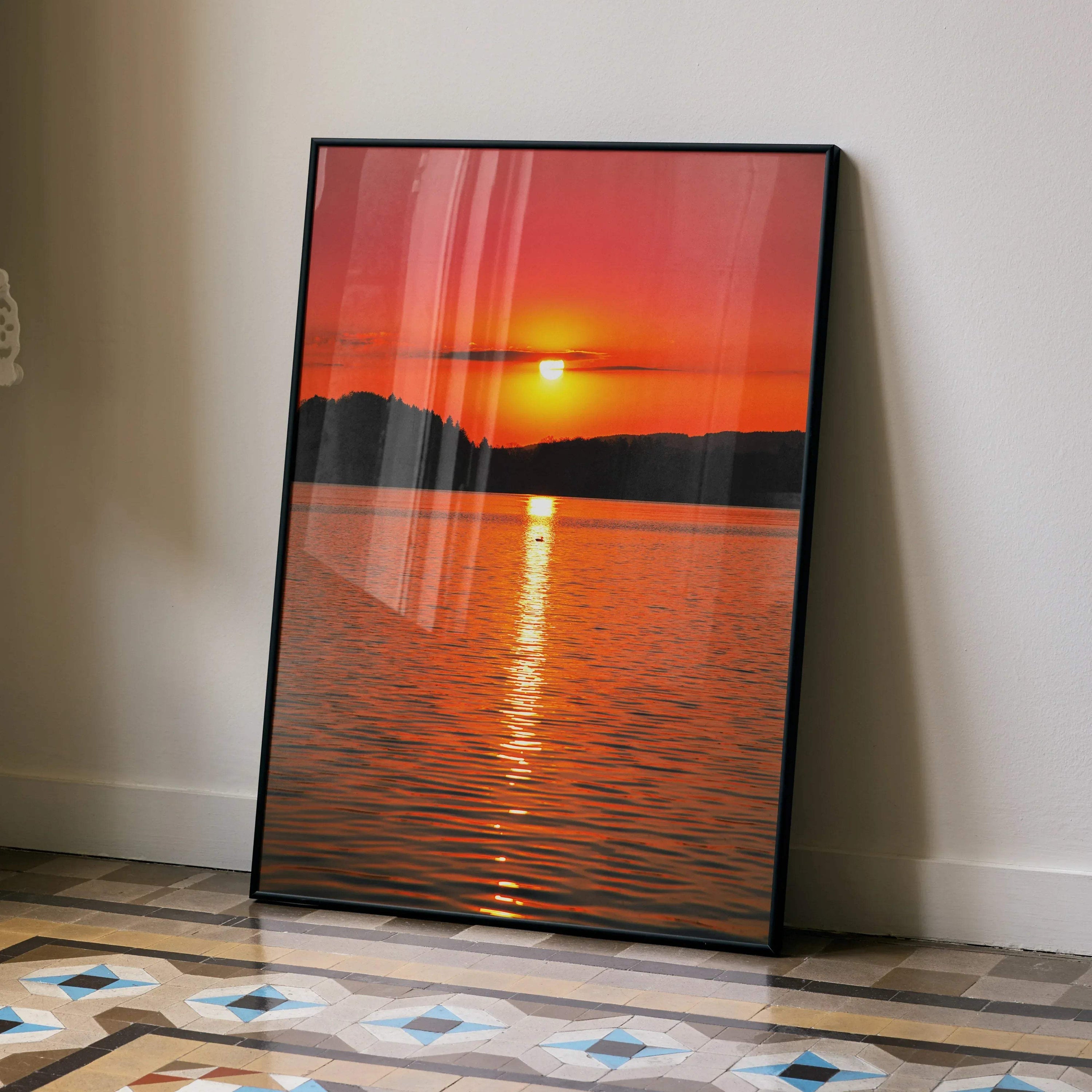 Vertical wall art poster featuring a serene orange and red ocean sunset over calm water with silhouetted landforms.