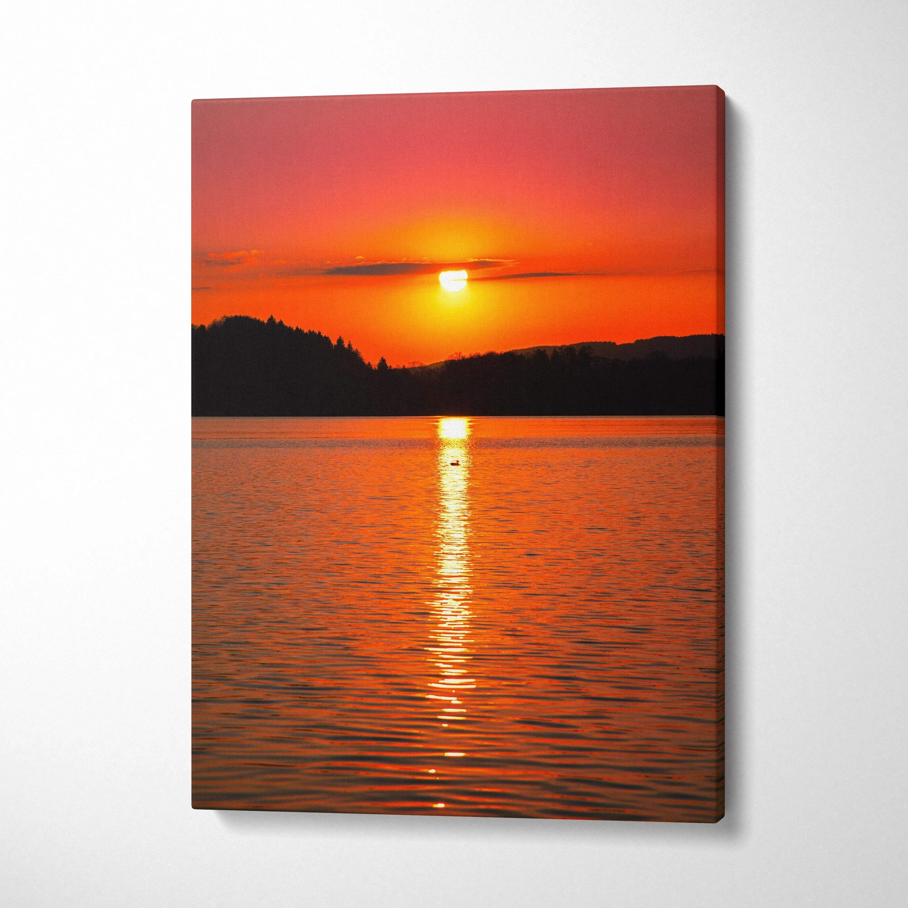 Vivid ocean sunset with bright orange sun over dark silhouette horizon on canvas wall art.