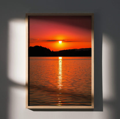 Serene ocean sunset wall art poster with vibrant orange sky and silhouetted shoreline in vertical frame.