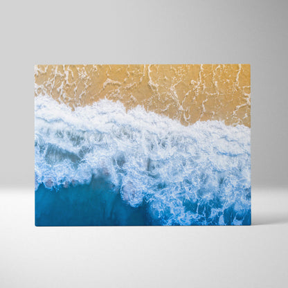 Beige and blue ocean wave canvas print featuring aerial shore photography for coastal living room or beach house decor