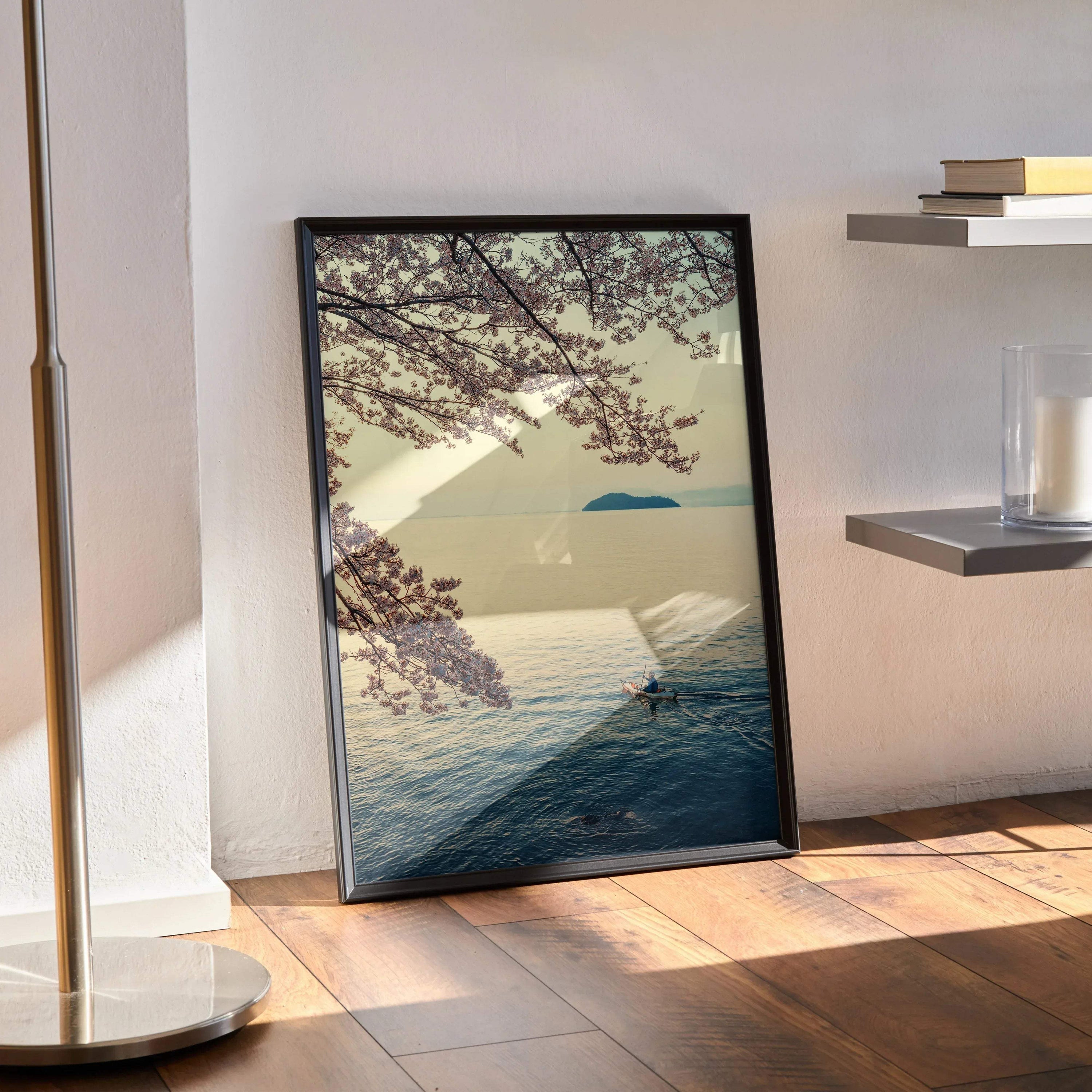 Serene ocean and cherry blossom branches poster wall art with soft pastel colors in black frame.